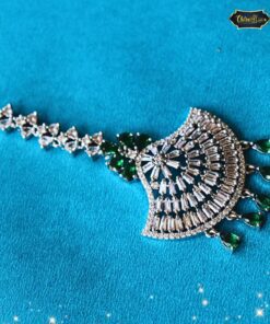 Emerald Radiance Maang Tikka with gold detailing and emerald centerpiece, designed as elegant forehead jewelry for weddings and traditional Indian occasions.