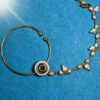 Designer Circular Nath featuring green Kundan center and pearl drop, a perfect traditional nose ring for ethnic and bridal wear.