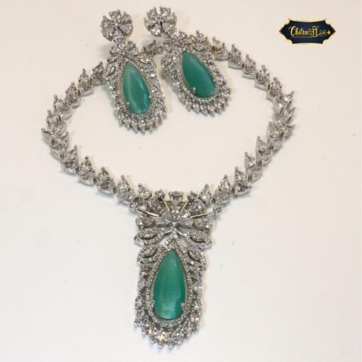 Close-up of a sparkling mint green teardrop CZ choker necklace with matching earrings on a soft, light-colored background.