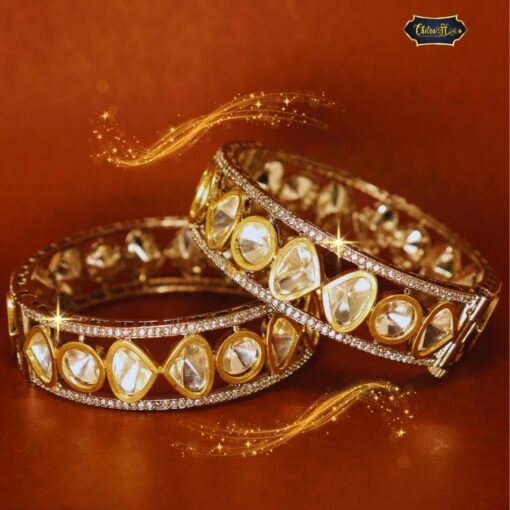 Gold-plated Celestial Dew Bangles with sparkling stone detailing, displayed on a velvet fabric background