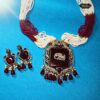 Maroon Monarch Necklace with antique elephant pendant and maroon beads, styled as tribal-inspired statement jewelry for festive or traditional wear.