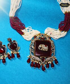 Maroon Monarch Necklace with antique elephant pendant and maroon beads, styled as tribal-inspired statement jewelry for festive or traditional wear.