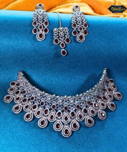 Red Teardrop Necklace Set with sparkling diamond-look stones, matching earrings, and maang tika displayed on an elegant bridal bust.