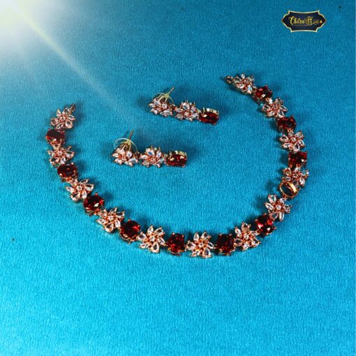 Golden Blaze Necklace featuring fiery red stones in a luxurious gold setting, paired with matching earrings for a complete festive and elegant jewelry look.