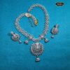 Silver Indian bridal jewelry set featuring floral necklace and matching bell-design earrings, displayed on traditional bridal attire.